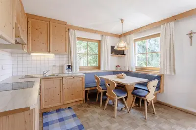 a kitchen with a table and chairs in a room at Villa Bernhard in Siusi