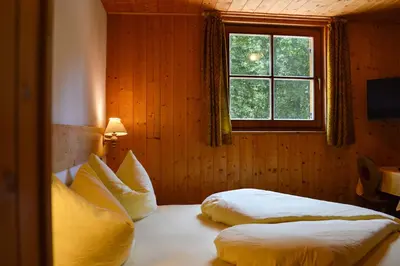 a bedroom with two beds and a window at Steinerhof in Braies