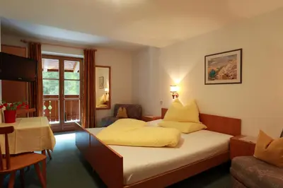 a bedroom with a bed with yellow pillows at Steinerhof in Braies