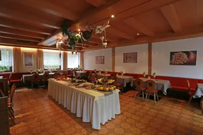 a banquet hall with tables and chairs with food on them at Steinerhof in Braies