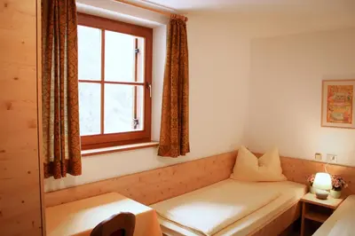 a room with a couch in front of a window at Steinerhof in Braies