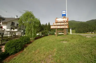 a sign for a albertoco restaurant on a hill at Steinerhof in Braies