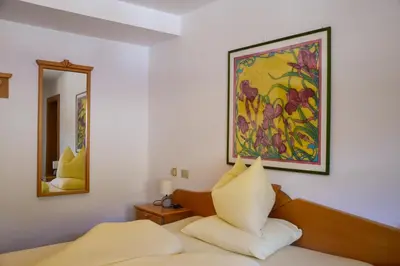 a bedroom with a bed and a painting on the wall at Steinerhof in Braies