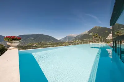 a swimming pool with a view of mountains at Hotel Tyrol in Schenna