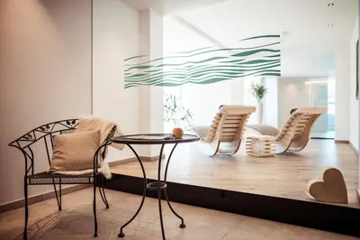 a living room with chairs and a table at Hotel Tyrol in Schenna