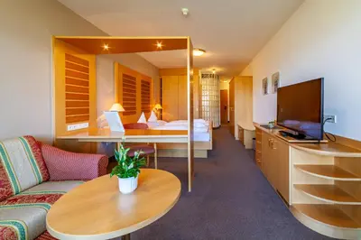 a hotel room with a bed and a couch and a table at Hotel Tyrol in Schenna