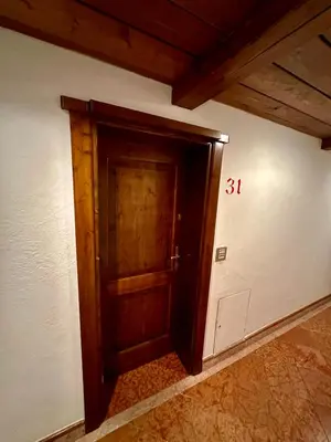 an empty room with a wooden door in a house at Harmony Apartment 31 in San Martino di Castrozza
