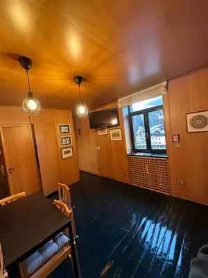 a dining room with a table and a window at Harmony Apartment 31 in San Martino di Castrozza