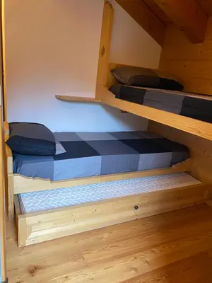 two bunk beds in a room with wooden floors at Precumon 16/5 in Arabba