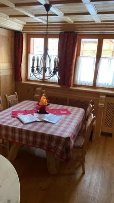 a dining room with a table with a lamp on it at Precumon 16/5 in Arabba