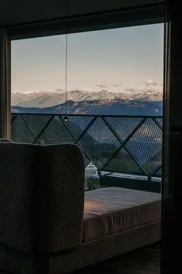 a chair sitting in front of a window with a view at Aparthotel My Daum in Nova Ponente