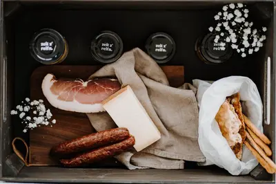 a basket of food with sausage and bread and cheese at Aparthotel My Daum in Nova Ponente