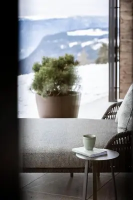 a coffee cup sitting on a table in front of a window at Aparthotel My Daum in Nova Ponente