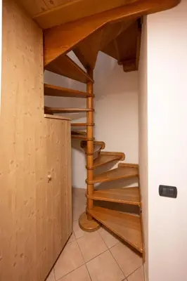 a spiral staircase in a room with wooden walls at Cesa Pecedel in Canazei