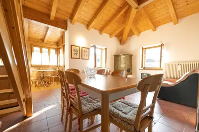 a dining room with a wooden table and chairs at Cesa Meida 3 in Pozza di Fassa