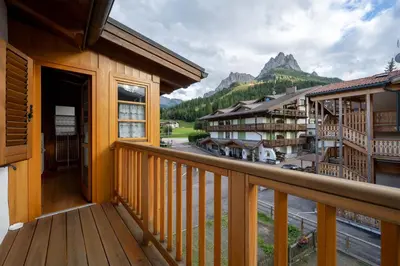 a balcony with a view of a town and mountains at Cesa Meida 3 in Pozza di Fassa