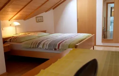 a bedroom with a bed and a table with a lamp at Millenniumshof in Caldaro