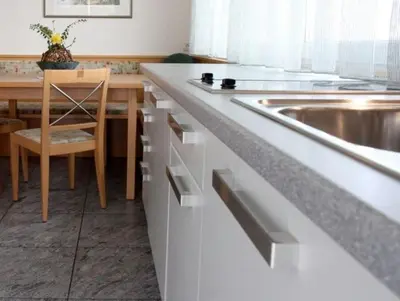 a kitchen with a sink and a wooden table at Millenniumshof in Caldaro