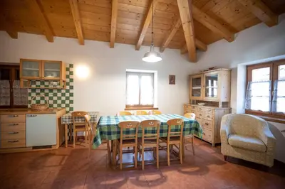 a kitchen and dining room with a table and chairs at Cesa Meida 4 in Pozza di Fassa