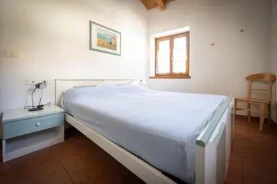 a bedroom with a bed with a blue dresser and a window at Cesa Meida 4 in Pozza di Fassa