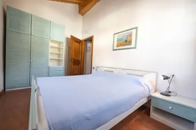 a bedroom with a large white bed and a nightstand at Cesa Meida 4 in Pozza di Fassa