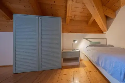 a bedroom with a bed and a wooden ceiling at Cesa Meida 4 in Pozza di Fassa