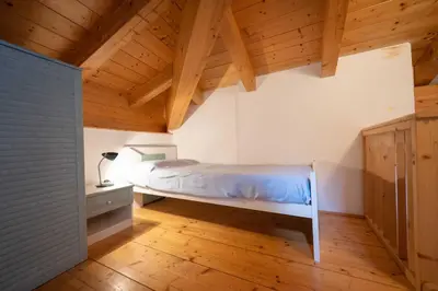 a bedroom with a bed and a wooden ceiling at Cesa Meida 4 in Pozza di Fassa
