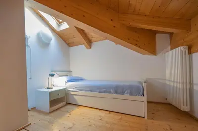 a bedroom with a bed and a wooden ceiling at Cesa Meida 4 in Pozza di Fassa