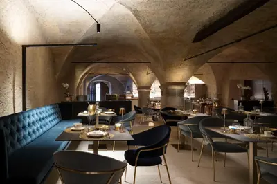 a restaurant with tables and chairs in a room at Ansitz Battisti Suites in Caldaro