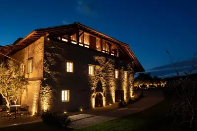 a building lit up at night with lights at Ansitz Battisti Suites in Caldaro