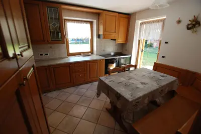 a kitchen with a table in the middle of it at Ciasa Rasom in Pozza di Fassa