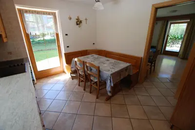 a kitchen with a table and chairs in a room at Ciasa Rasom in Pozza di Fassa