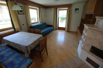 a living room with a table and a couch at Ciasa Rasom in Pozza di Fassa