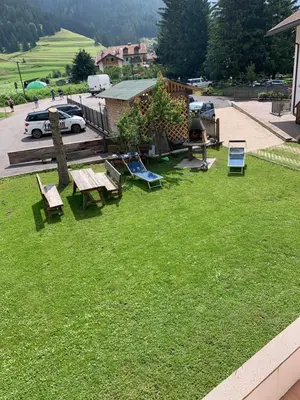 a park with picnic tables and chairs on the grass at Ciasa Rasom in Pozza di Fassa