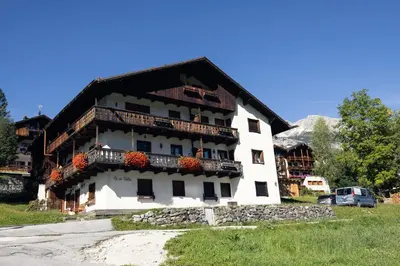 a large white building with flowers on the balconies at Casa Betulla in Cortina dʼAmpezzo
