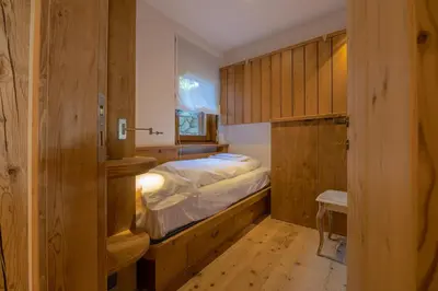 a small bedroom with a bed and a window at Casa Betulla in Cortina dʼAmpezzo