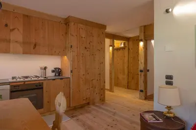 a kitchen with wooden walls and wooden floors at Casa Betulla in Cortina dʼAmpezzo