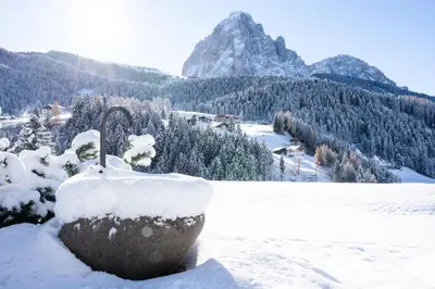 a snow covered rock with a mountain in the background at Villa Carolina in Selva di Val Gardena