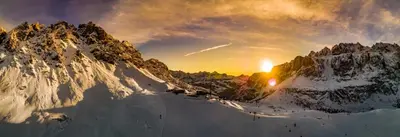 a winter sunset over a snowy mountain range at Villa Carolina in Selva di Val Gardena