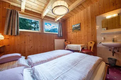 a bedroom with two beds and a sink in it at Apartments Vintlana in Selva