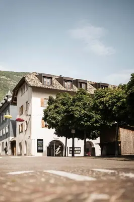 an overhead view of a white building with a tiled roof at Schmitte am Sonnenwirtsplatz Eppan in South Tyrol, perfect starting point for bike and hike in Appiano sulla Strada del Vino