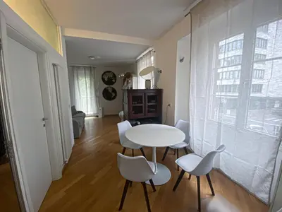 a dining room with a white table and chairs at Living Vittoria: vicino al Centro di Bolzano in Bolzano
