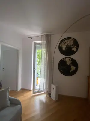 a living room with a couch and a sliding glass door at Living Vittoria: vicino al Centro di Bolzano in Bolzano