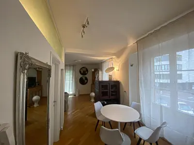 a dining room with a white table and chairs at Living Vittoria: vicino al Centro di Bolzano in Bolzano
