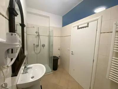 a bathroom with a sink and a shower with a glass door at Living Vittoria: vicino al Centro di Bolzano in Bolzano