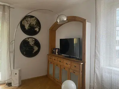 a living room with a tv and a mirror at Living Vittoria: vicino al Centro di Bolzano in Bolzano