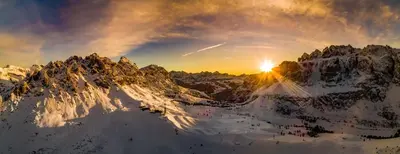 a sunset over a snow covered mountain range at Chalet Villa Carolina in Selva di Val Gardena