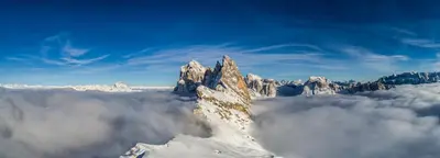 a mountain covered in snow and clouds in the sky at Chalet Villa Carolina in Selva di Val Gardena