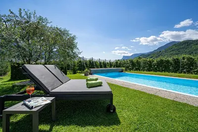 a backyard with a couch and a table next to a pool at Appartements Kreuzwegerhof in Lana