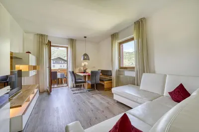 a living room with a white couch and a table at Appartements Kreuzwegerhof in Lana